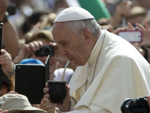 Pope Francis drinks from a mate gourd, a traditional South American cup, he was offered as he arrives for his weekly general audience, in Saint Peter's Square, at the Vatican, May 20, 2015. (Credit: AP Photo/Andrew Medichini)