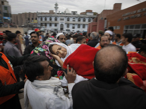 People rush an injured woman to a local hospital in Peshawar, Pakistan, after a powerful 7.7-magnitude earthquake in northern Afghanistan rocked cities across South Asia, with strong tremors that were felt in Kabul, New Delhi and Islamabad and in the Pakistani capital, walls swayed back and forth and people poured out of office buildings in a panic, reciting verses from the Quran, October 26, 2015 (Credit: AP Photo/Mohammad Sajjad)