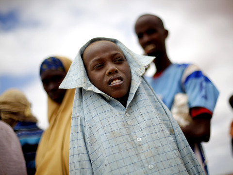 Somali children stand at the burial of 12-month-old Liin Muhumed Surow at UNHCR's Ifo Extention camp outside Dadaab, Eastern Kenya, 100 kms (60 miles) from the Somali border, August 6, 2011 (Credit: AP Photo/Jerome Delay)