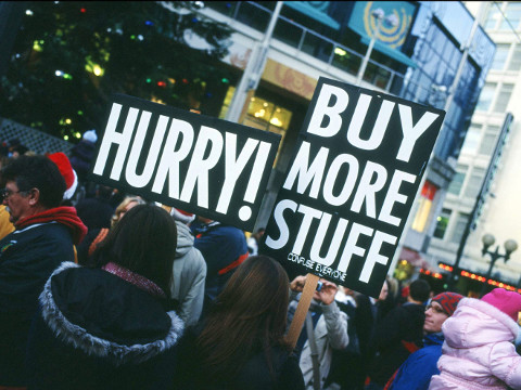 On Black Friday in 2010, Buy More Stuff campaigners were out in force with signs at the Seattle Westlake Shopping Center, Seattle, Washington, November 26, 2010 (Credit: John Henderson via Flickr)