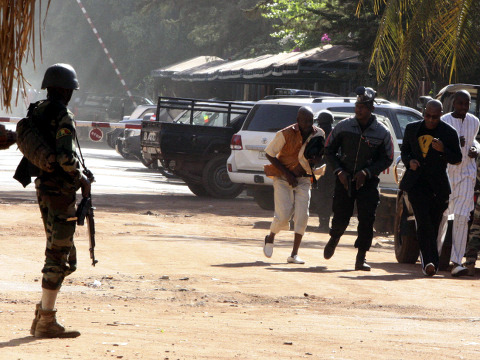 People run to flee from the Radisson Blu Hotel in Bamako, Mali, where assailants have taken hostages in a brazen assault involving grenades, November 20, 2015 (Credit: AP Images/Harouna Traore)