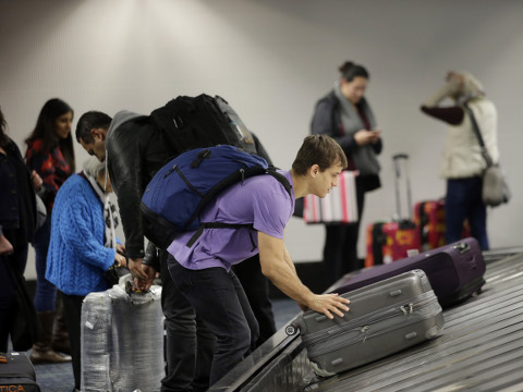 A traveler gathers his luggage at the San Francisco International Airport Sunday, San Francisco, November 22, 2015 (Credit: AP Photo/Marcio Jose Sanchez)