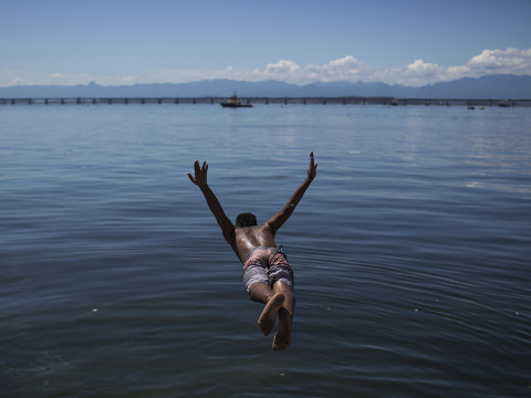 A young man dives into the polluted waters of Guanabara Bay in Rio de Janeiro, Brazil, October 31, 2015 (Credit: AP Photo/Felipe Dana)