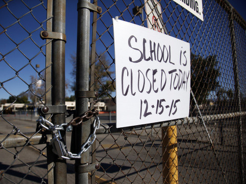 A gate to Birmingham Community Charter High School is locked with a sign stating that school is closed, after all schools in the vast Los Angeles Unified School District, the nation's second largest, were ordered closed due to an electronic threat, December 15, 2015 (AP Photo/Danny Moloshok)