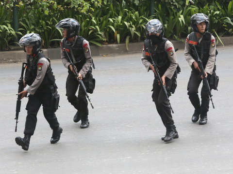 Police officers rush to take their position at the site of an attack where attackers set off explosions at a Starbucks cafe in a bustling shopping area in Indonesia's capital and waged gunbattles with police Thursday, leaving bodies in the streets as office workers watched in terror from high-rise buildings, Jakarta, Indonesia, January 14, 2016 (Credit: AP Photo/Tatan Syuflana)
