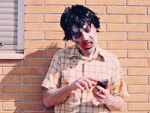 Scary zombie using a smartphone (Credit: Nito via Fotolia)