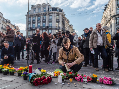 People light candles at a memorial set up outside the stock exchange in Brussels on Tuesday, March 22, 2016. Explosions, at least one likely caused by a suicide bomber, rocked the Brussels airport and subway system Tuesday, prompting a lockdown of the Belgian capital and heightened security across Europe. (AP Photo/Geert Vanden Wijngaert)