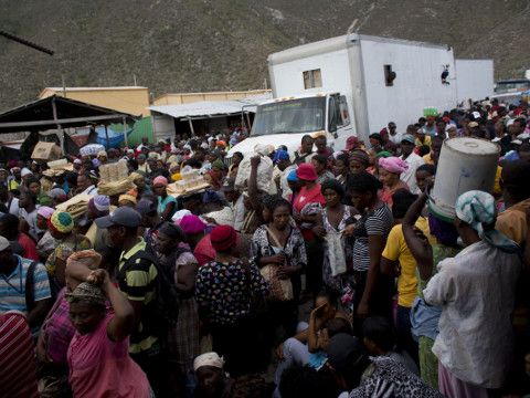 Haitians wait for the opening of the border between Jimani, Dominican Republic, and Malpasse, Haiti, on a market day, Thursday, June 18, 2015. As the Dominican Republic starts cracking down on migrants, the Dominican government is urging people to start carrying documents to prove they're residents and avoid deportation in case immigration agents stop them. (AP Photo/Rebecca Blackwell)