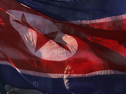 A North Korean man carries his country's national flag at the Pyongyang Indoor Stadium where people gathered for a mass dance party to celebrate the