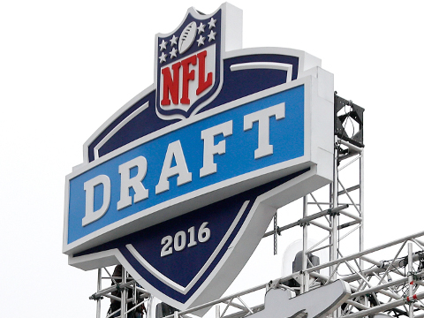 A work crew hangs a Draft Town sign in preparation for the 2016 NFL Draft at Grant Park on Tuesday, April 26, 2016 in Chicago. (Ben Liebenberg via AP)