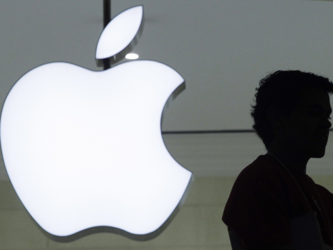 FILE - In a Wednesday, Dec. 7, 2011, file photo, a person stands near the Apple logo at the company's store in Grand Central Terminal, in New York. There's a shadowy global industry devoted to unlocking phones and extracting their information. For digital forensics companies, success can mean big bucks in the form of government contracts. And the notoriety that could come with cracking an iPhone used by a purported terrorist could rocket them to cyber stardom. (AP Photo/Mark Lennihan, File)