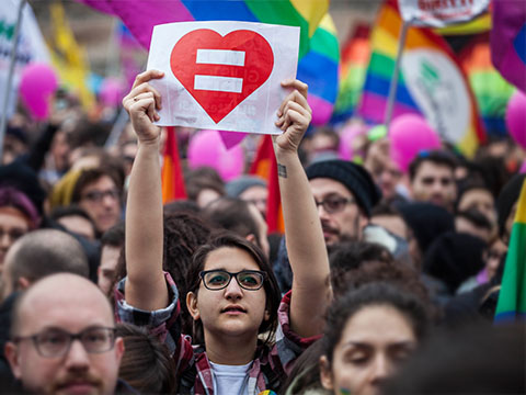 A demonstrator holds a placard depicting a heart with an equal sign as he takes part in a protest against the bill on civil union which was approved recently by the Italian Senate in Rome, Italy.