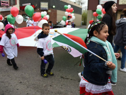 A large Mexican flag is carried down Vernor Hwy during the 52nd annual Cinco de Mayo parade Sunday, May 1, 2016, in Detroit's Southwest community. Cinco de Mayo commemorates the May 5, 1862 defeat of the invading French army by Mexican forces at Puebla. (Tanya Moutzalias/The Ann Arbor News via AP)