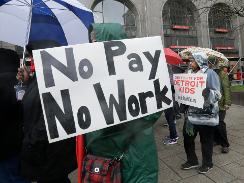 Detroit teachers march outside the district headquarters, Monday, May 2, 2016, in Detroit. Nearly all of Detroit's public schools were closed Monday and more than 45,000 students missed classes after about half the district's teachers called out sick to protest the possibility that some of them will not get paid over the summer if the struggling district runs out of cash. (AP Photo/Carlos Osorio)