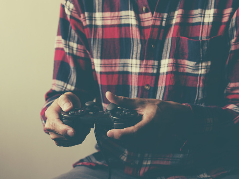 young man holding game controller playing video games (Credit: wayne_0216 via fotolia)