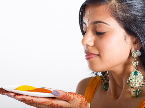 Young Indian woman holds a plate with turmeric (Credit: Underground Health)