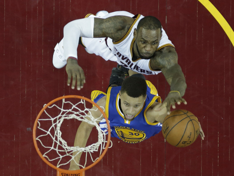 Golden State Warriors’ Stephen Curry, bottom, drives to the basket against Cleveland Cavaliers' LeBron James in the second half in Game 6 of the NBA basketball Finals, Thursday, June 16, 2016, in Cleveland. The Cavaliers won 115-101. (AP Photo/Ron Schwane)