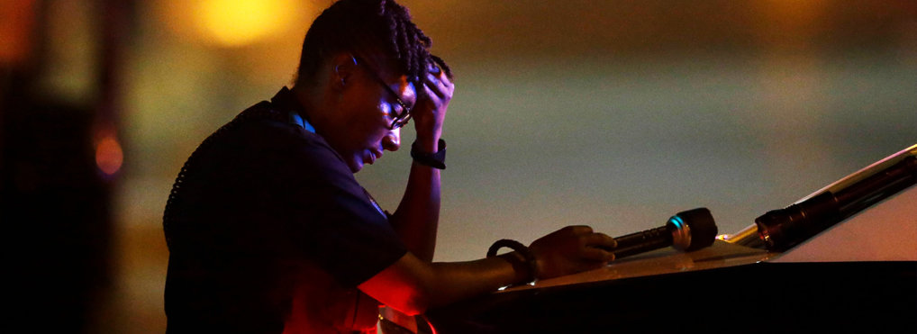 A Dallas police officer, who did not want to be identified, takes a moment as she guards an intersection in the early morning after a shooting in downtown Dallas, Friday, July 8, 2016. At least two snipers opened fire on police officers during protests in Dallas on Thursday night; some of the officers were killed, police said.