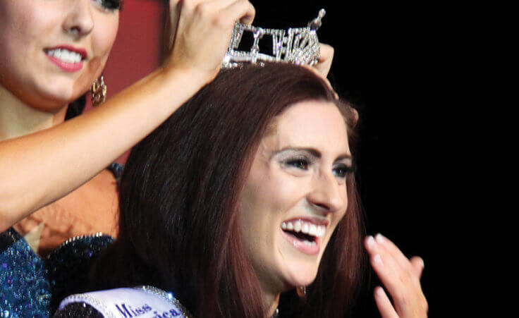 In this Saturday, June 18, 2016 photo, Miss Missouri 2016 Erin O'Flaherty is being crowned by Miss Missouri 2015 McKensie Garber and the new 2016 Miss Missouri's Outstanding Teen Christina Stratton, her arm seen, in Mexico, Mo. Missouri has its first openly gay Miss Missouri, and she will represent the state at the Miss America pageant later this year.