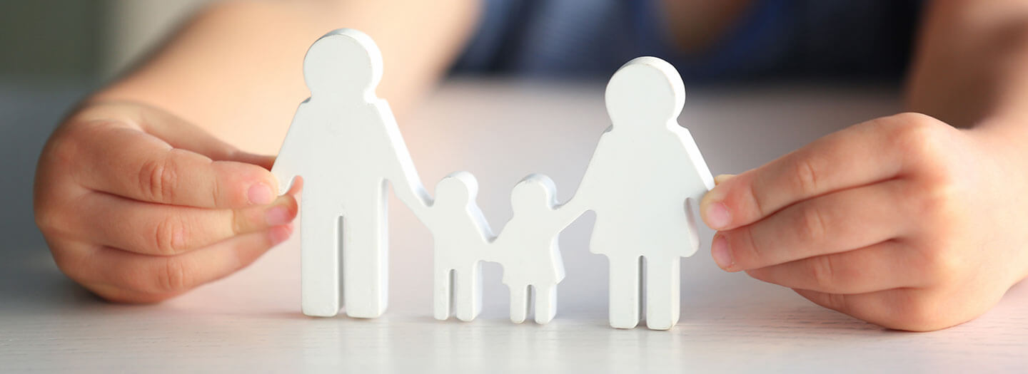 A child holds up cutouts of a family unit.