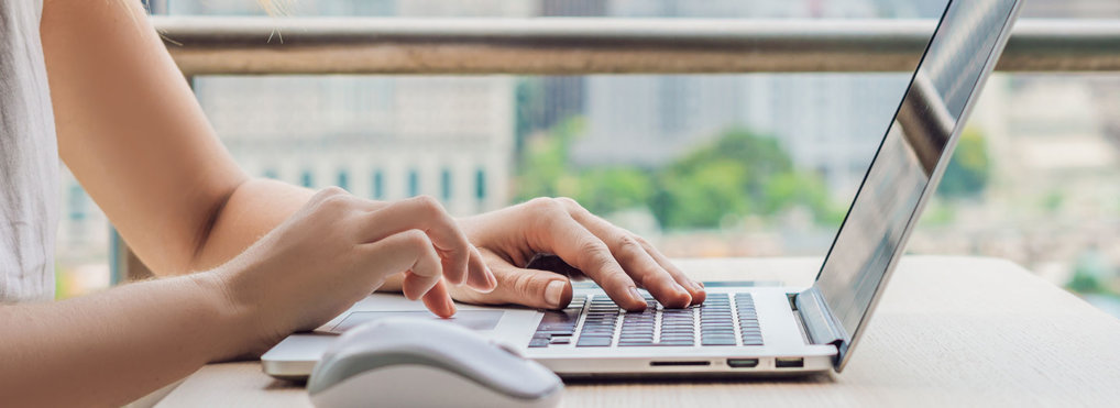 A woman types on a laptop computer.