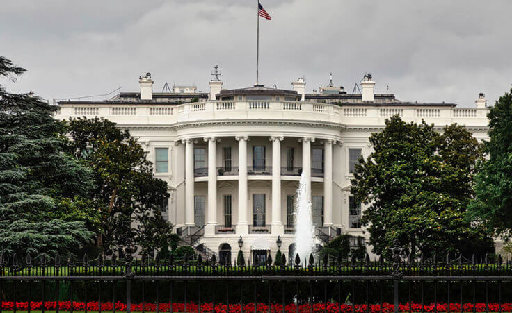 The White House sits under a stormy sky