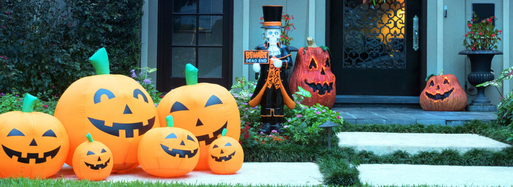 Inflatable pumpkins and a ghostly decoration sit outside of a home