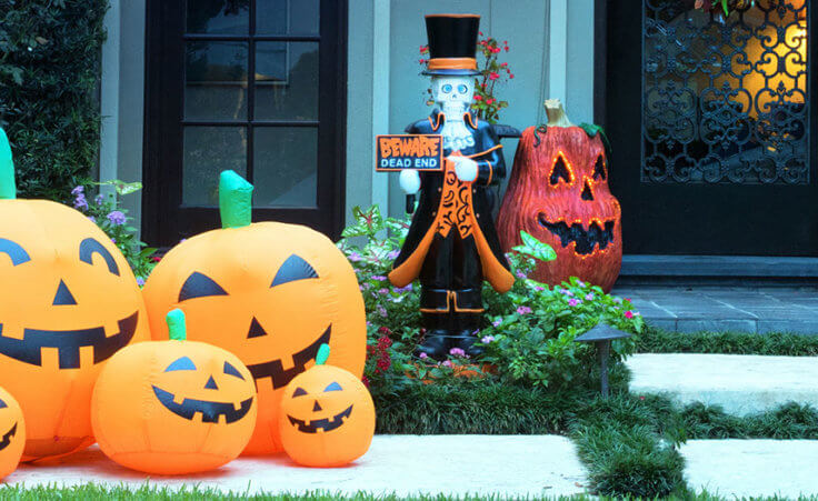 Inflatable pumpkins and a ghostly decoration sit outside of a home