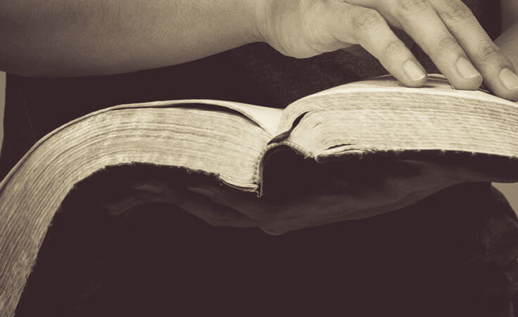 A man holds an open Bible