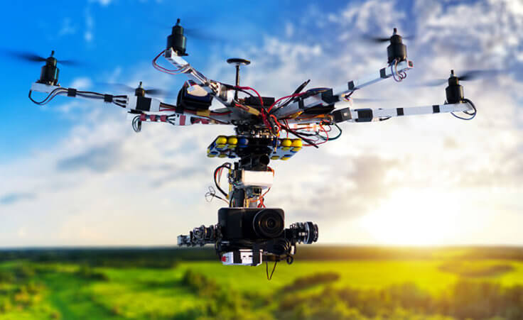 A drone hovers high above a forested area