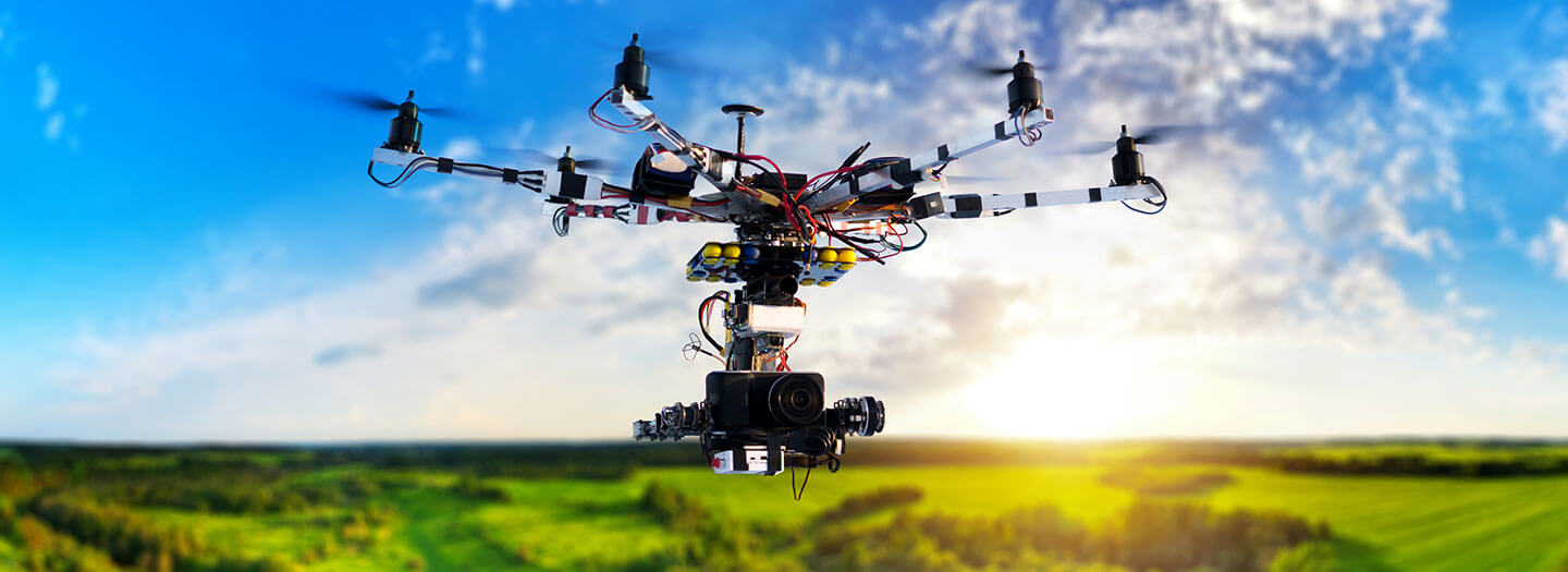 A drone hovers high above a forested area