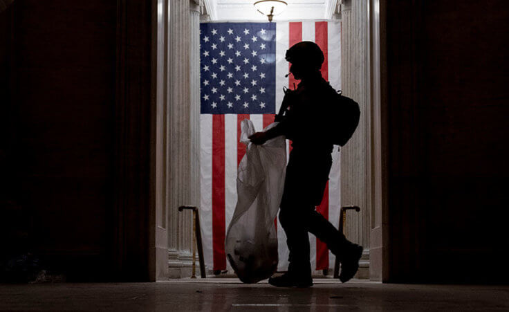 An ATF police officer cleans up debris and personal belongings strewn across the floor of the Rotunda in the early morning hours of Thursday, Jan. 7, 2021, after protesters stormed the Capitol in Washington, on Wednesday.