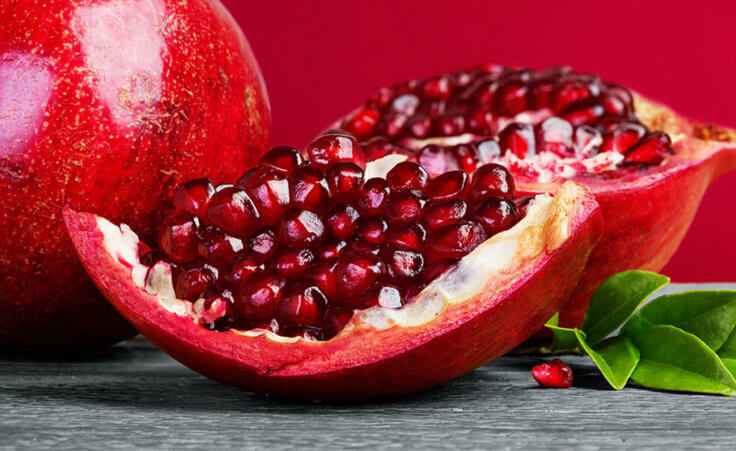 An open pomegranate revealing its red seeds