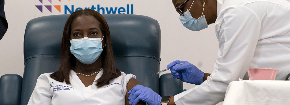Sandra Lindsay, left, a nurse at Long Island Jewish Medical Center, is inoculated with the Pfizer-BioNTech COVID-19 vaccine by Dr. Michelle Chester, Monday, Dec. 14, 202