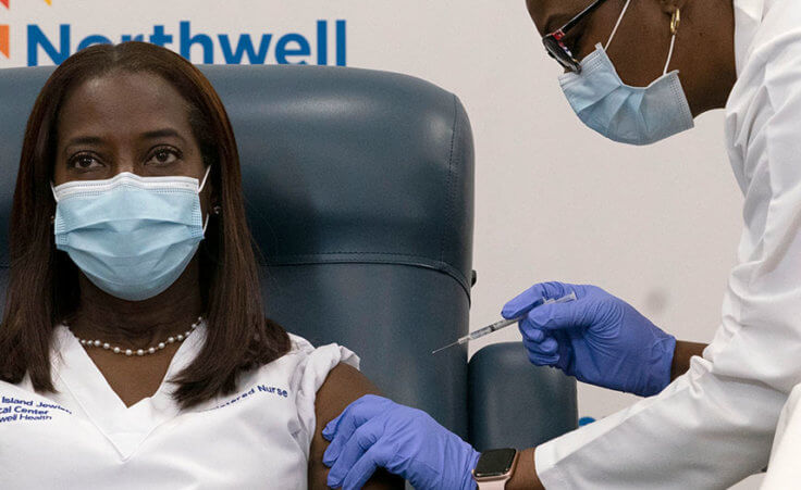 Sandra Lindsay, left, a nurse at Long Island Jewish Medical Center, is inoculated with the Pfizer-BioNTech COVID-19 vaccine by Dr. Michelle Chester, Monday, Dec. 14, 202