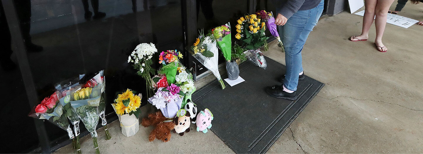 FILE - In this March 17, 2021, file photo, Jessica Lang pauses and places her hand on the door in a moment of grief after dropping off flowers with her daughter Summer at Youngs Asian Massage parlor where four people were killed in Acworth, Ga. (Curtis Compton/Atlanta Journal-Constitution via AP, File)