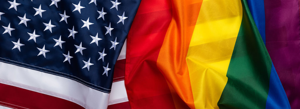A rainbow flag draped over an American flag