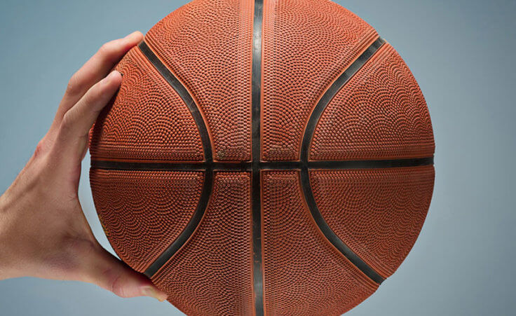 One hold holds out a basketball