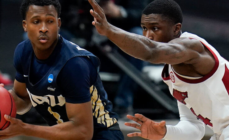 Oral Roberts guard Max Abmas, left, drives around Arkansas guard Davonte Davis, right, during the first half of a Sweet 16 game in the NCAA men's college basketball tournament at Bankers Life Fieldhouse, Saturday, March 27, 2021, in Indianapolis. (AP Photo/Jeff Roberson)