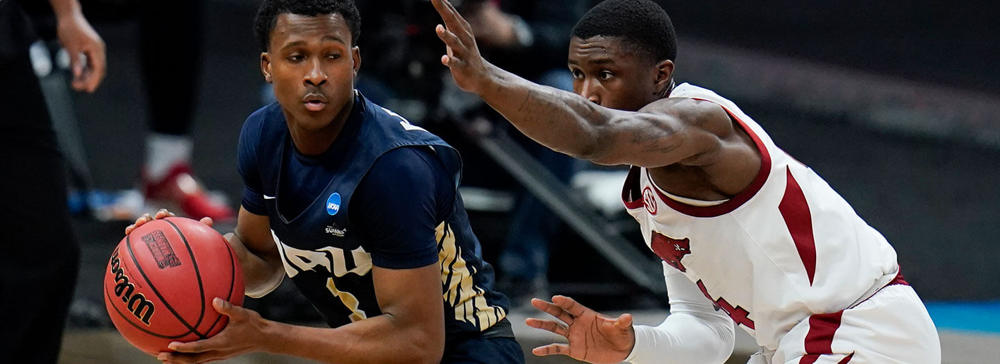 Oral Roberts guard Max Abmas, left, drives around Arkansas guard Davonte Davis, right, during the first half of a Sweet 16 game in the NCAA men's college basketball tournament at Bankers Life Fieldhouse, Saturday, March 27, 2021, in Indianapolis. (AP Photo/Jeff Roberson)