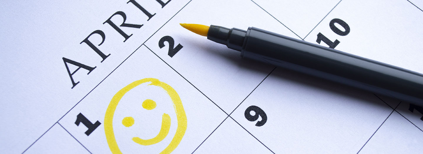 A yellow smiley face is drawn onto a calendar denoting April 1, aka April Fools' Day