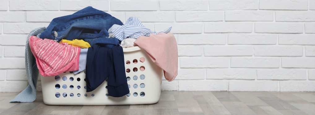 A laundry basket overflows with dirty laundry