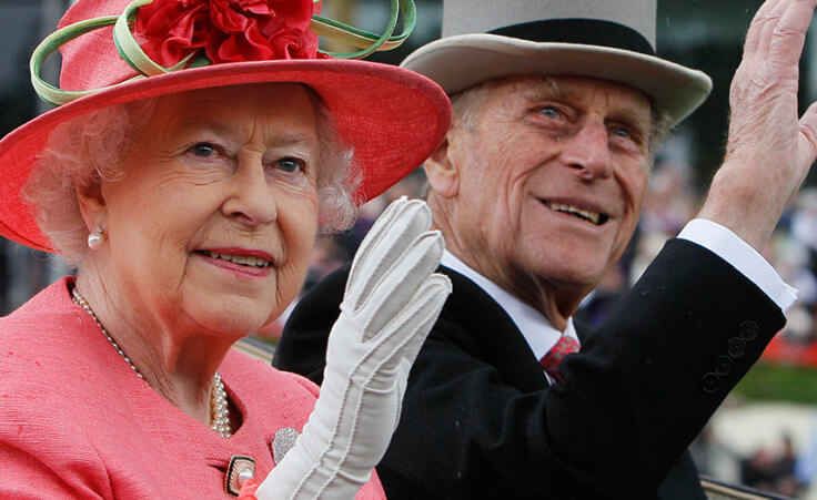 Queen Elizabeth and Prince Philip wave from a horse-drawn carriage.