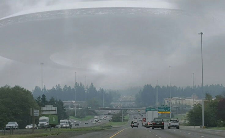 A UFO hovers within clouds above a busy highway