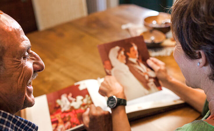 An older couple looks at their wedding album