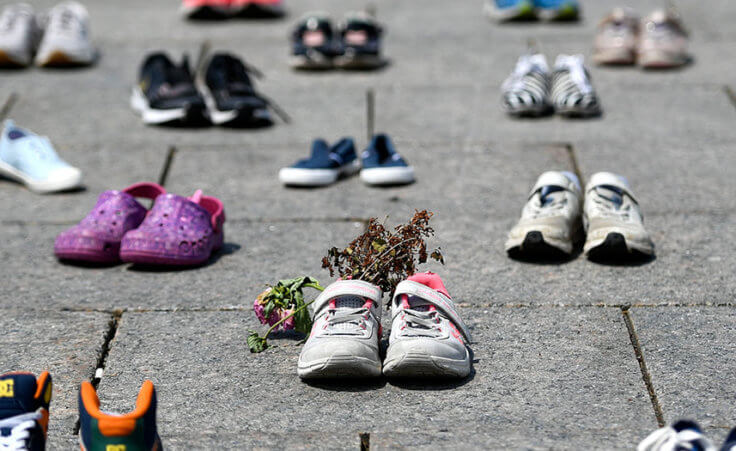 Dried flowers rest inside a pair of child's running shoes at a memorial for the 215 children whose remains were found at the grounds of the former Kamloops Indian Residential School