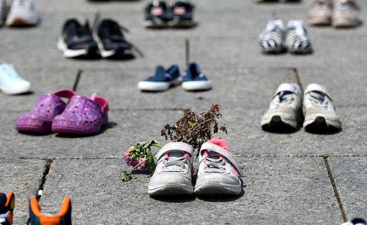 Dried flowers rest inside a pair of child's running shoes at a memorial for the 215 children whose remains were found at the grounds of the former Kamloops Indian Residential School