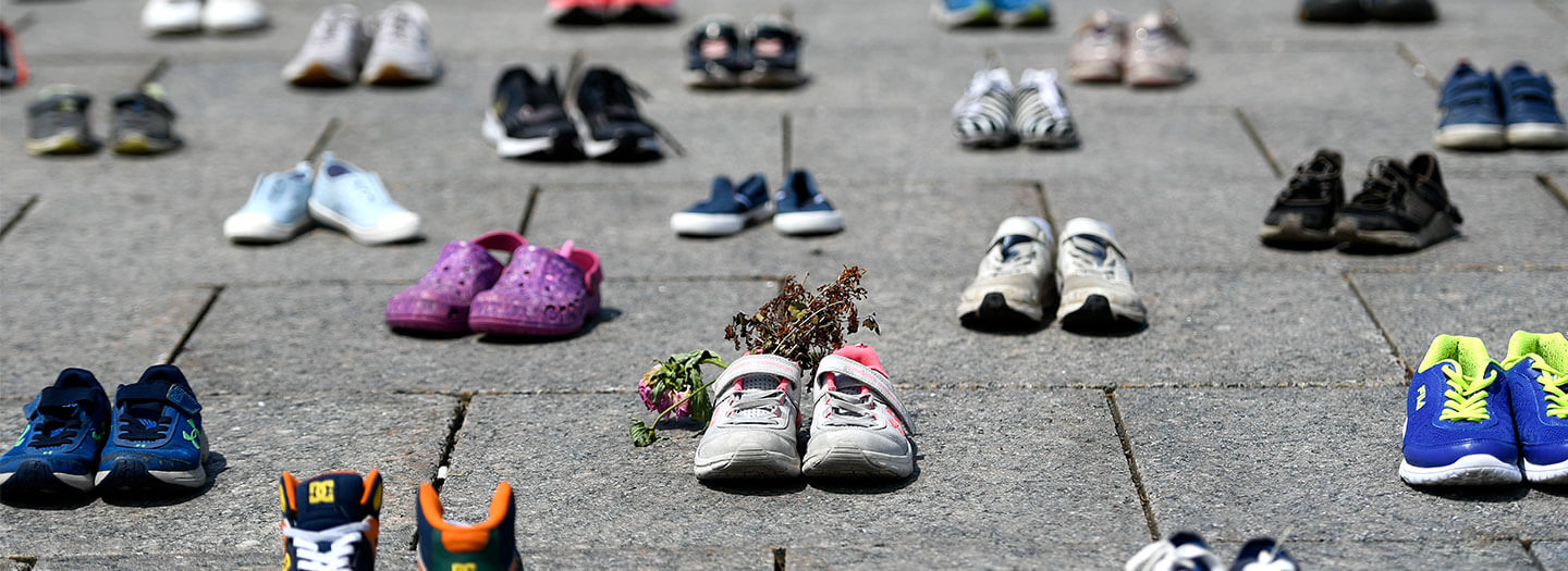 Dried flowers rest inside a pair of child's running shoes at a memorial for the 215 children whose remains were found at the grounds of the former Kamloops Indian Residential School