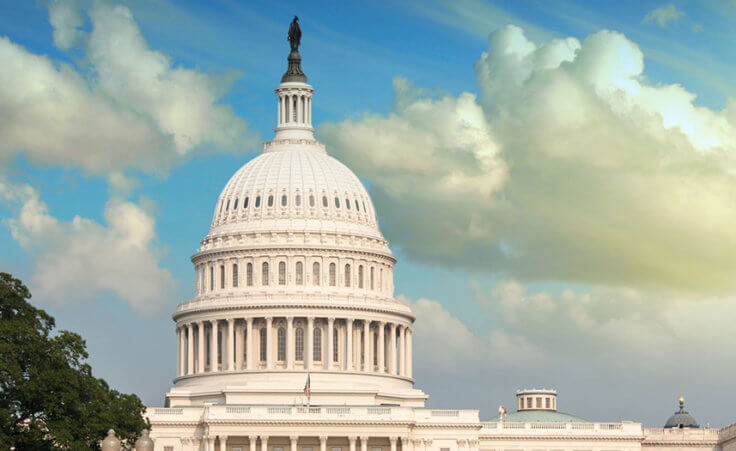 The US Capitol building with luminous blue skies and white clouds