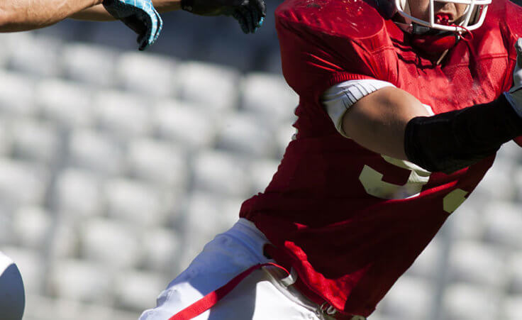 A college football player makes a diving catch